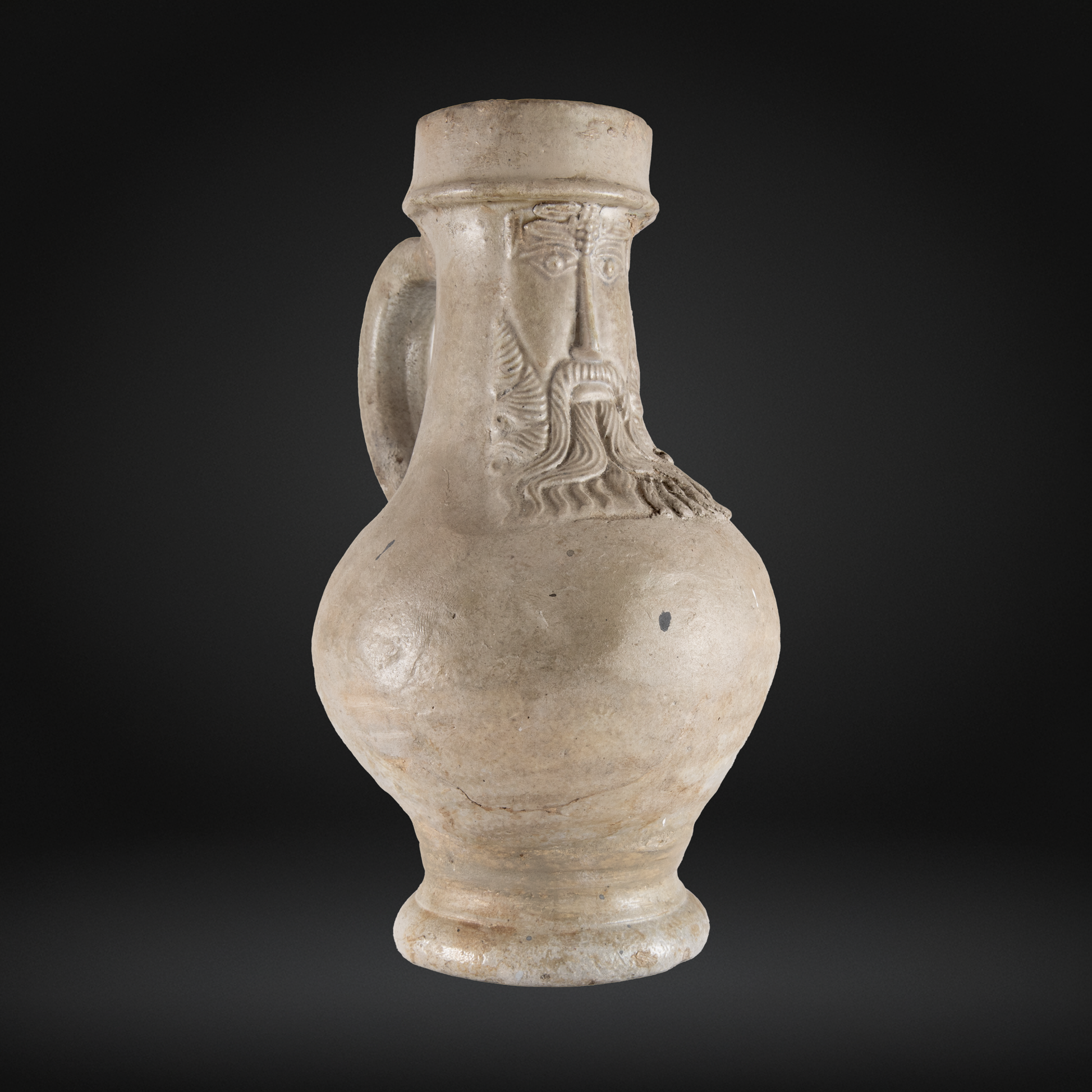 16th Century Raeren Salt Glaze Stoneware Bellarmine Jug featuring a bearded face mask, handcrafted German antique pottery with a pale beige glaze and rounded body.