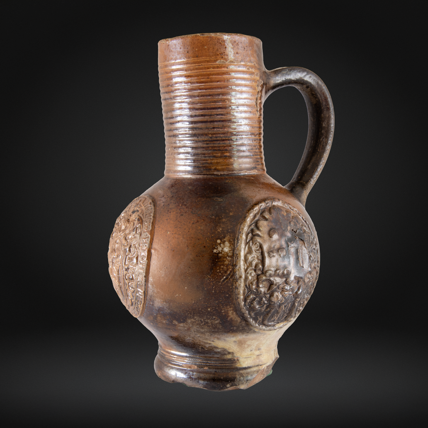 16th Century Raeren Stoneware Armorial Jug with a rounded body, embossed medallions, ribbed neck, and single handle showcasing German stoneware craftsmanship from the Renaissance period.