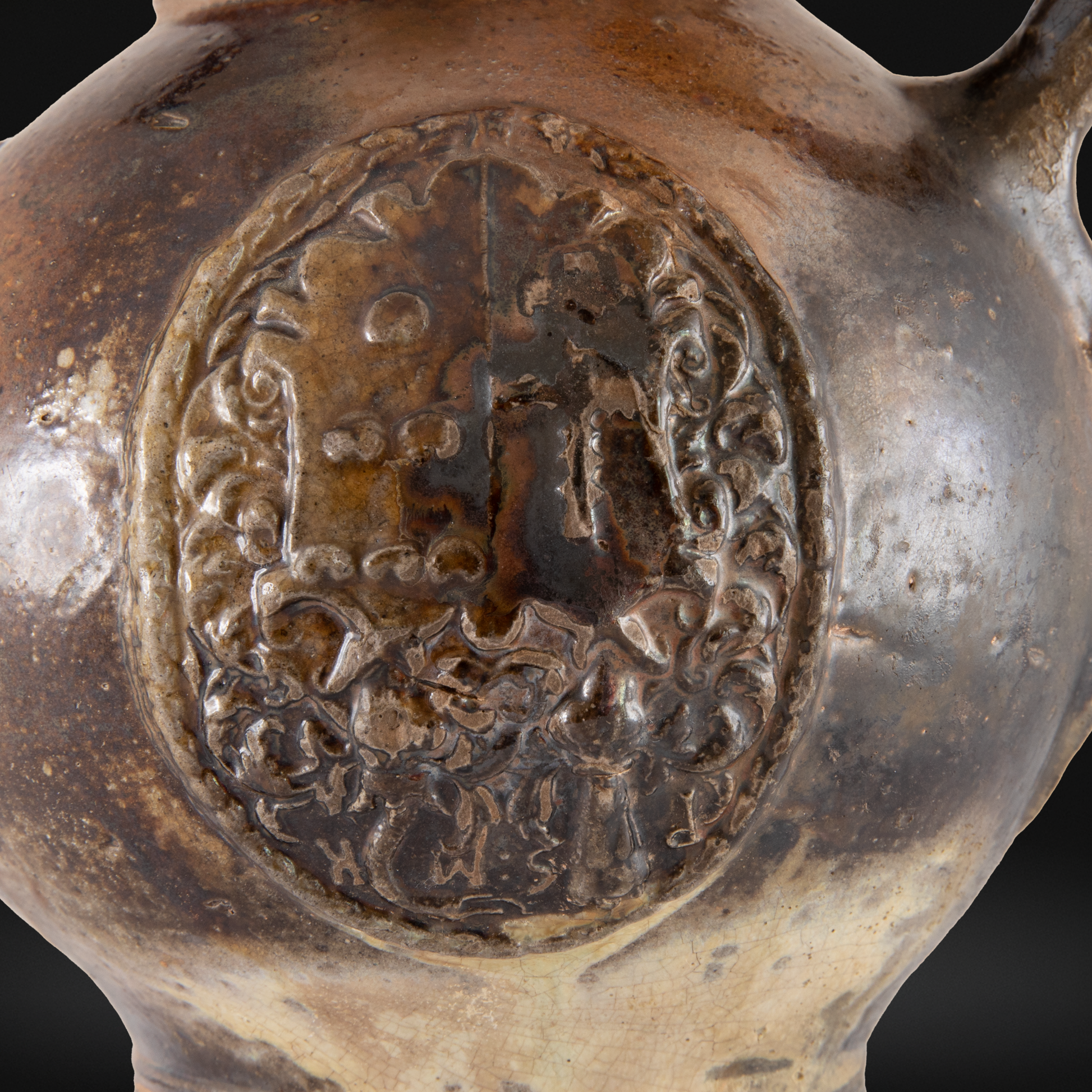 Close-up of a detailed embossed emblem on a 16th Century Raeren Stoneware Armorial Jug showcasing antique German stoneware craftsmanship.