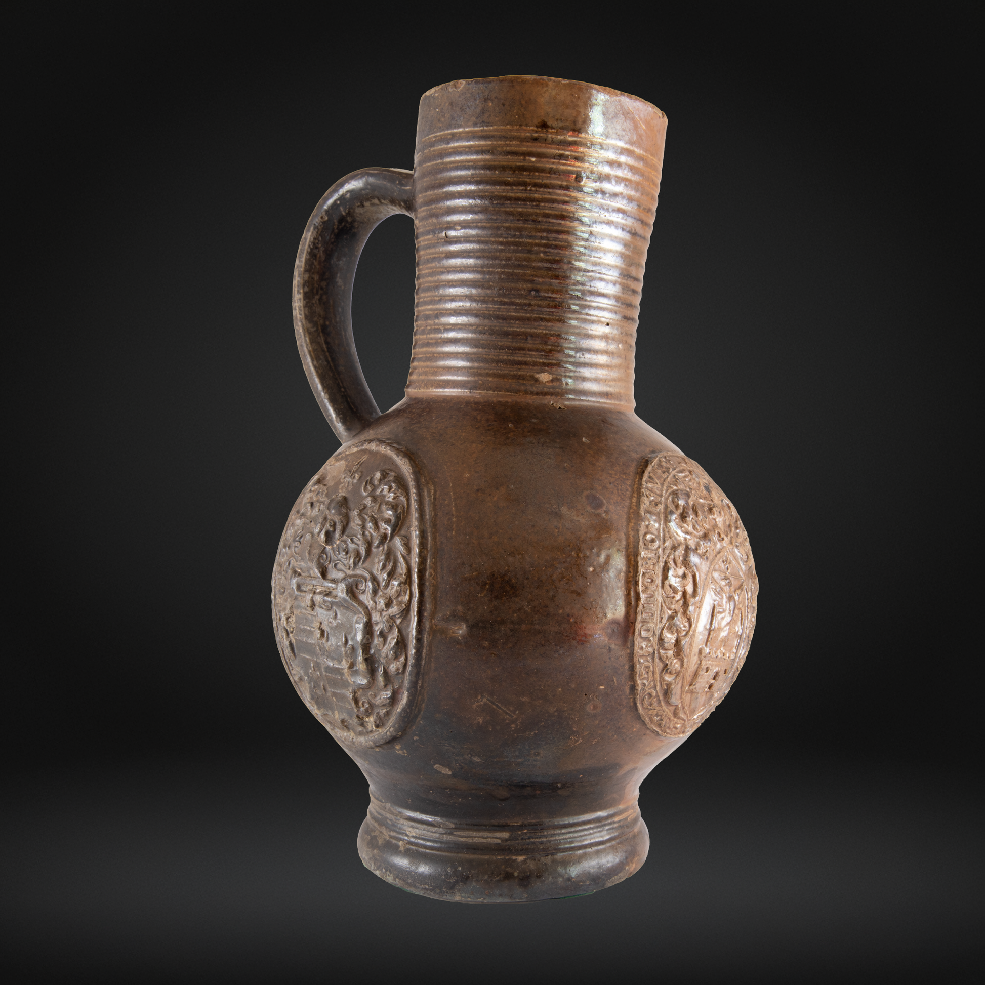 16th Century Raeren Stoneware Armorial Jug with detailed heraldic medallions and ribbed neck, showcasing antique German stoneware craftsmanship.