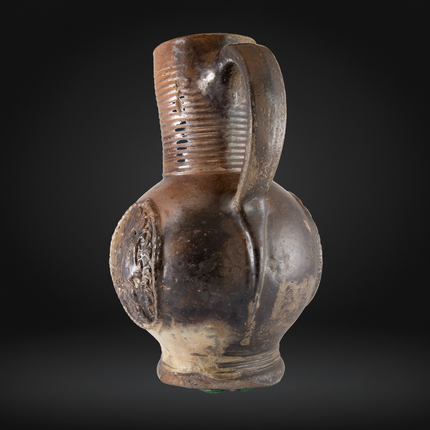 16th Century Raeren Stoneware Armorial Jug in dark brown German stoneware with a single handle and raised heraldic medallion on the side.